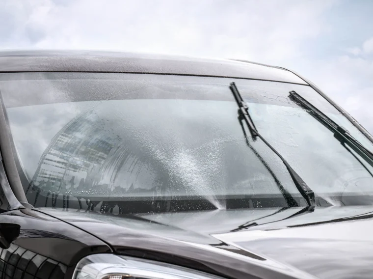 A vehicle's windshield wipers clearing of moisture on its windshield.