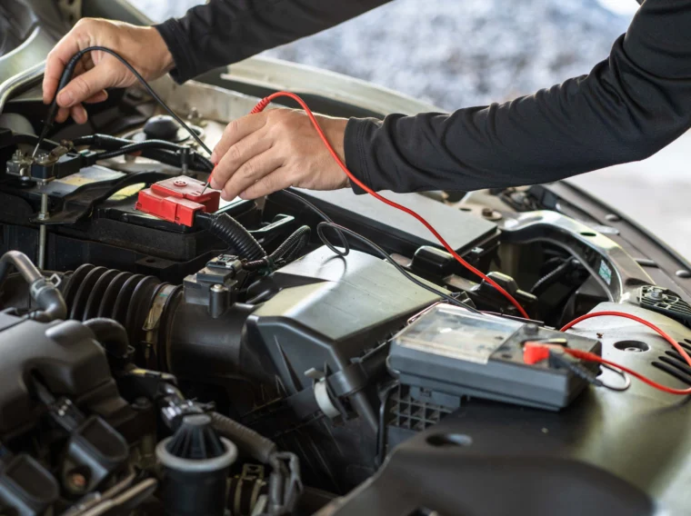 Hand of mechanic man holding multimeter tool for battery inspection.