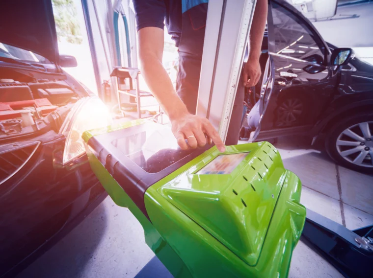 Worker checks and adjusts the headlights of a car's lighting system.