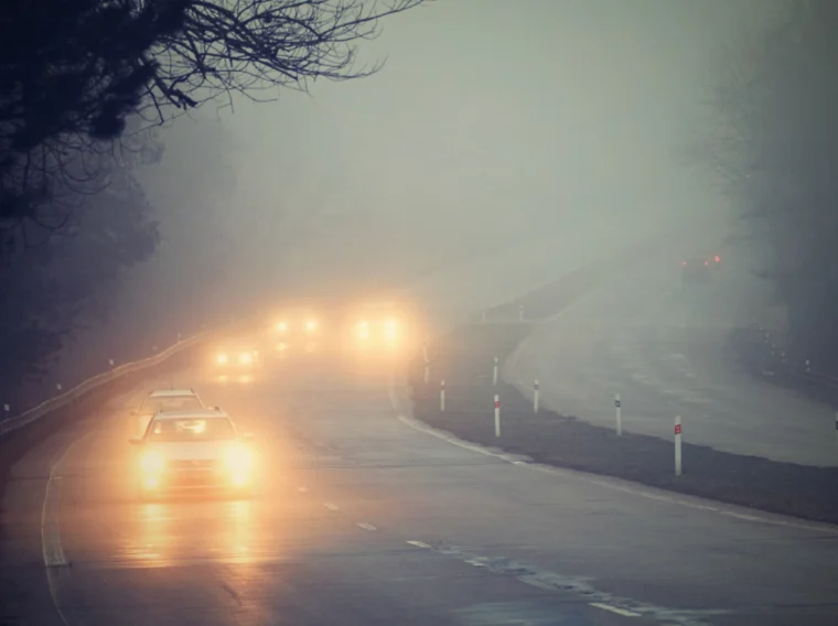 Cars driving in the fog on split road.
