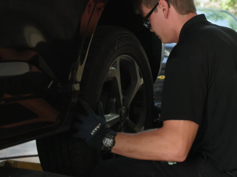 A technician rotating the tire of a vehicle.